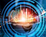 A person holds a tablet displaying rising, multicolored bar graphs with flames and circular digital graphics layered over the image, symbolizing rapid data growth.