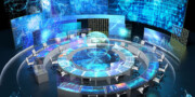 Futuristic control room with circular desks, multiple computer screens, and large digital displays showing maps, data graphs, and global networks.