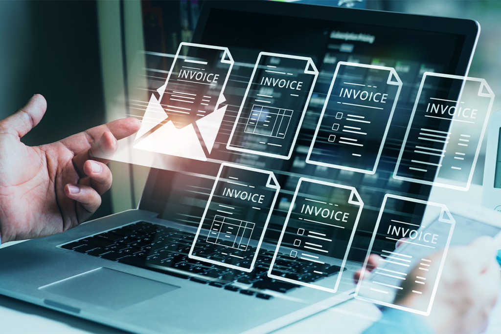A person interacts with a laptop displaying virtual invoice icons, symbolising digital invoicing or online billing processes.